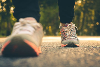 Low section of man wearing shoes on road