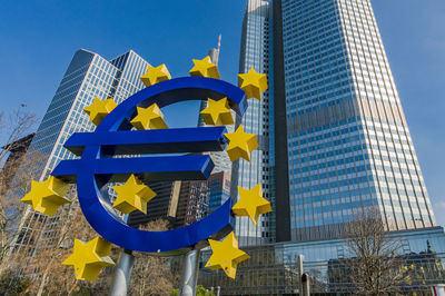 Euro sign in frankfurt in front of skyscrapers