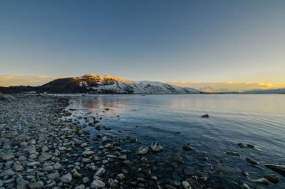 Scenic view of sea against clear sky at sunset