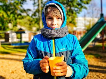 Portrait of boy holding drink in cup