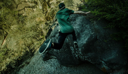 Man surfing on rock in forest