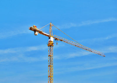 Low angle view of crane against blue sky