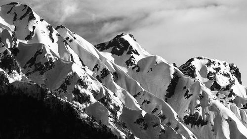 Low angle view of snowcapped mountains against sky