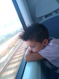 Boy looking through window in train