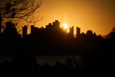 Silhouette buildings against sky during sunset