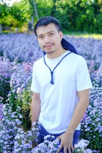 Portrait of young man standing against plants