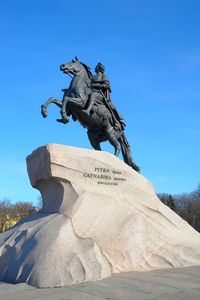 Low angle view of statue against blue sky