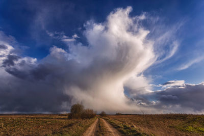 Road amidst field against sky