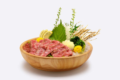 Close-up of fresh vegetables in bowl against white background