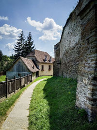 Footpath amidst buildings against sky