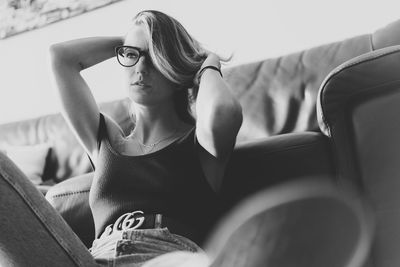 Midsection of woman sitting on sofa at home