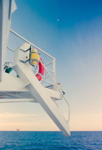 Boat in sea against clear blue sky