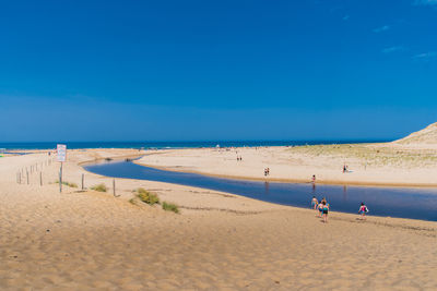 Scenic view of beach against blue sky