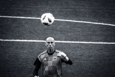 Portrait of man holding ball on soccer field