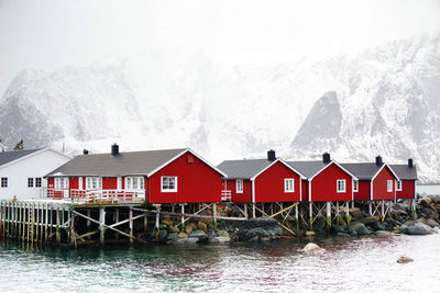 Houses by snowcapped mountains against sky