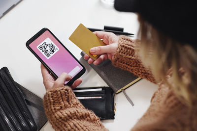 Woman's hands holding cell phone and credit card