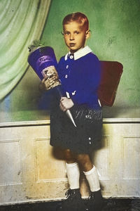 High angle view of boy holding camera at home