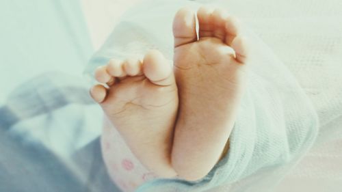 Close-up of baby hand on bed