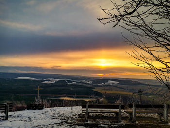 Scenic view of snowcapped mountains against sky at sunset