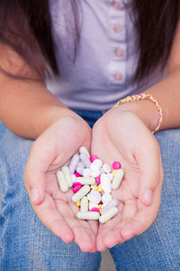 Midsection of woman holding medicines in cupped hands