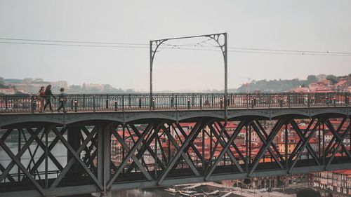 Bridge over river in city against clear sky