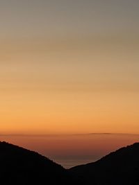 Scenic view of silhouette mountains against romantic sky at sunset
