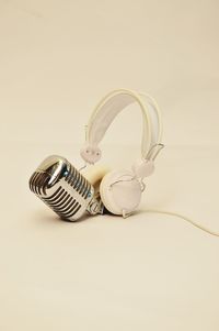 Close-up of microphone and headphones over white background