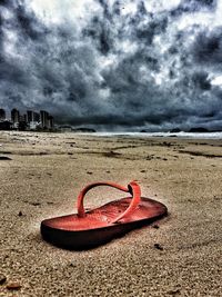 Scenic view of beach against cloudy sky