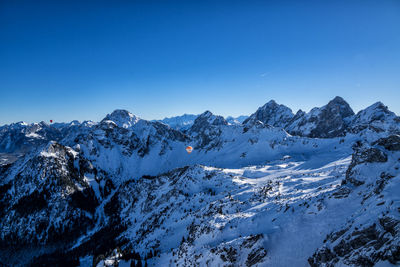 Scenic view of snowcapped mountains against clear blue sky