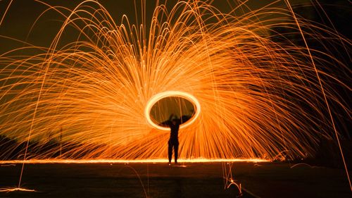 Person spinning wire wool at night