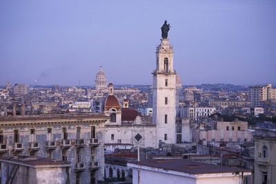 Buildings in city against clear sky