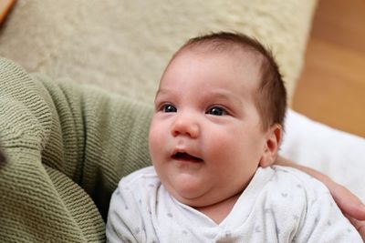 Cute baby boy looking away at home