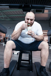 Full length of man sitting with arms raised