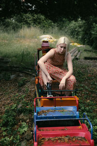 Young woman sitting on miniature train