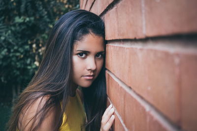 Portrait of beautiful woman standing against wall