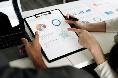 Midsection of business colleagues working on table