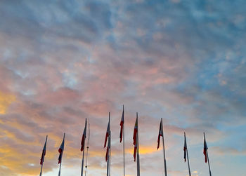 Low angle view of flags against sky at sunset