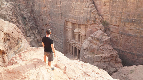 High angle view of man standing on cliff against jabal al-madbah