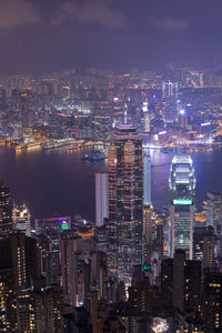 Illuminated buildings in city against sky at night