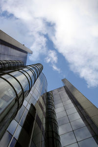 Low angle view of modern building against cloudy sky