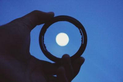 Person holding umbrella against clear sky