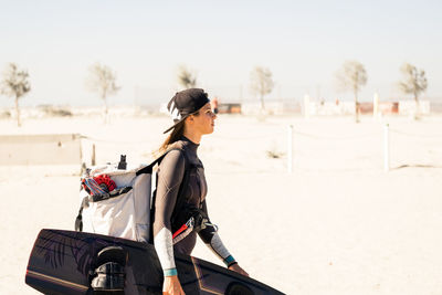 Side view of young woman standing on snow