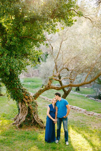 Couple kissing near tree in forest