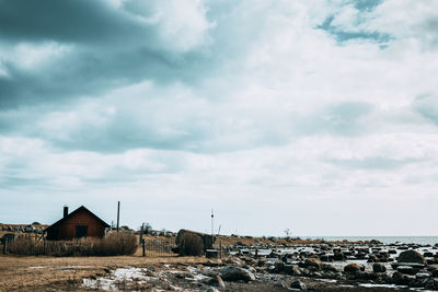 Houses by sea against sky