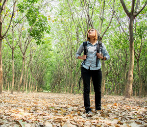 Woman standing against trees in forest