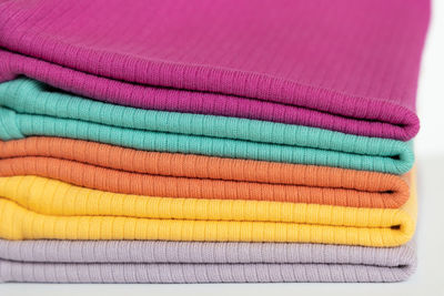 Stack folded colorful baby cotton clothing on white background isolation. fabric full frame shot