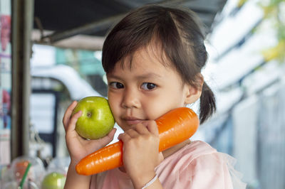 Portrait of cute girl holding apple
