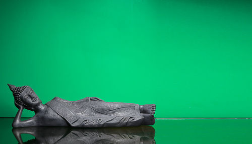 Close-up of shoes on table against green background