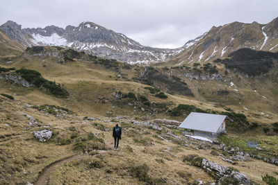 Full length of woman standing on field against mountain