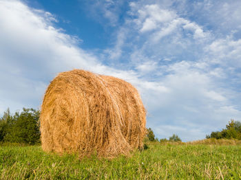 Hay bales on field against sky